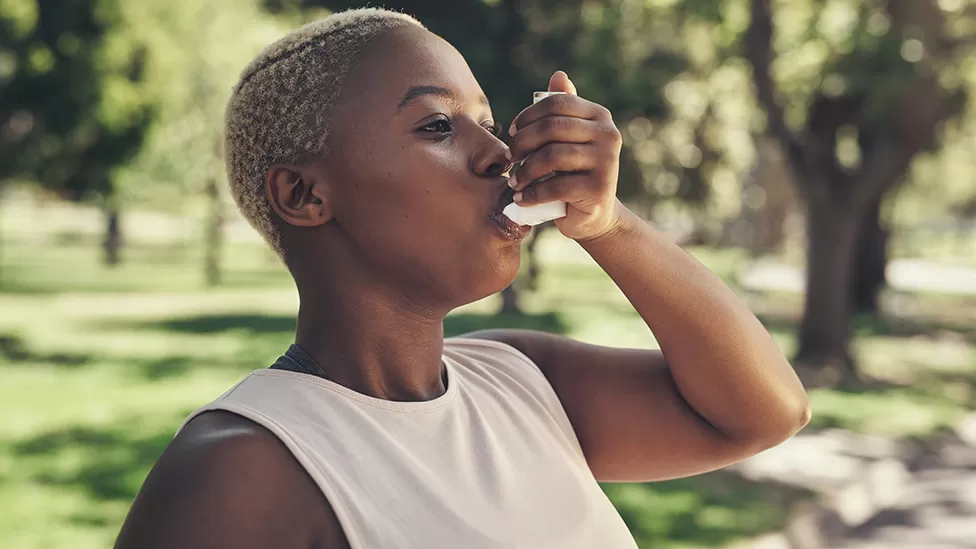 A woman using an inhaler